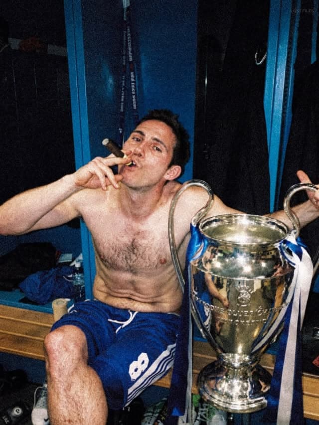 Frank Lampard with a cigar and the Champions League trophy in the dressing room